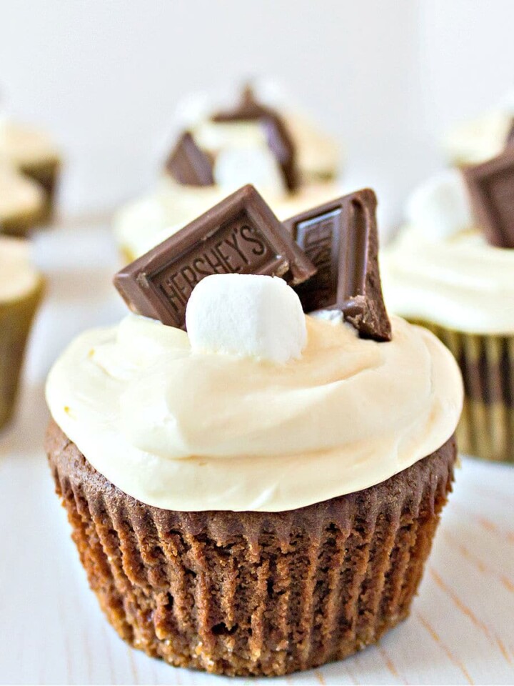 smores cupcakes lined up with a marshmallow and piece of chocolate on top