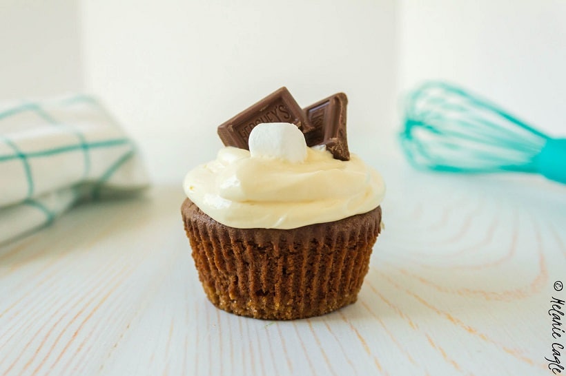 Close up of a smores cupcake with a marshmallow and some chocolate on top.