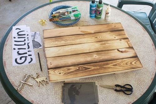 outdoor table with board and paint ready for crafting