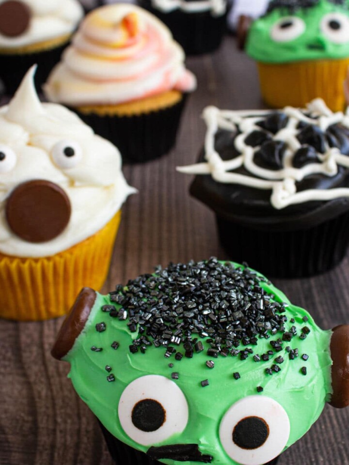 close up of halloween cupcakes, with ghost cupcake, frankenstein cupcake, spiderweb cupcake