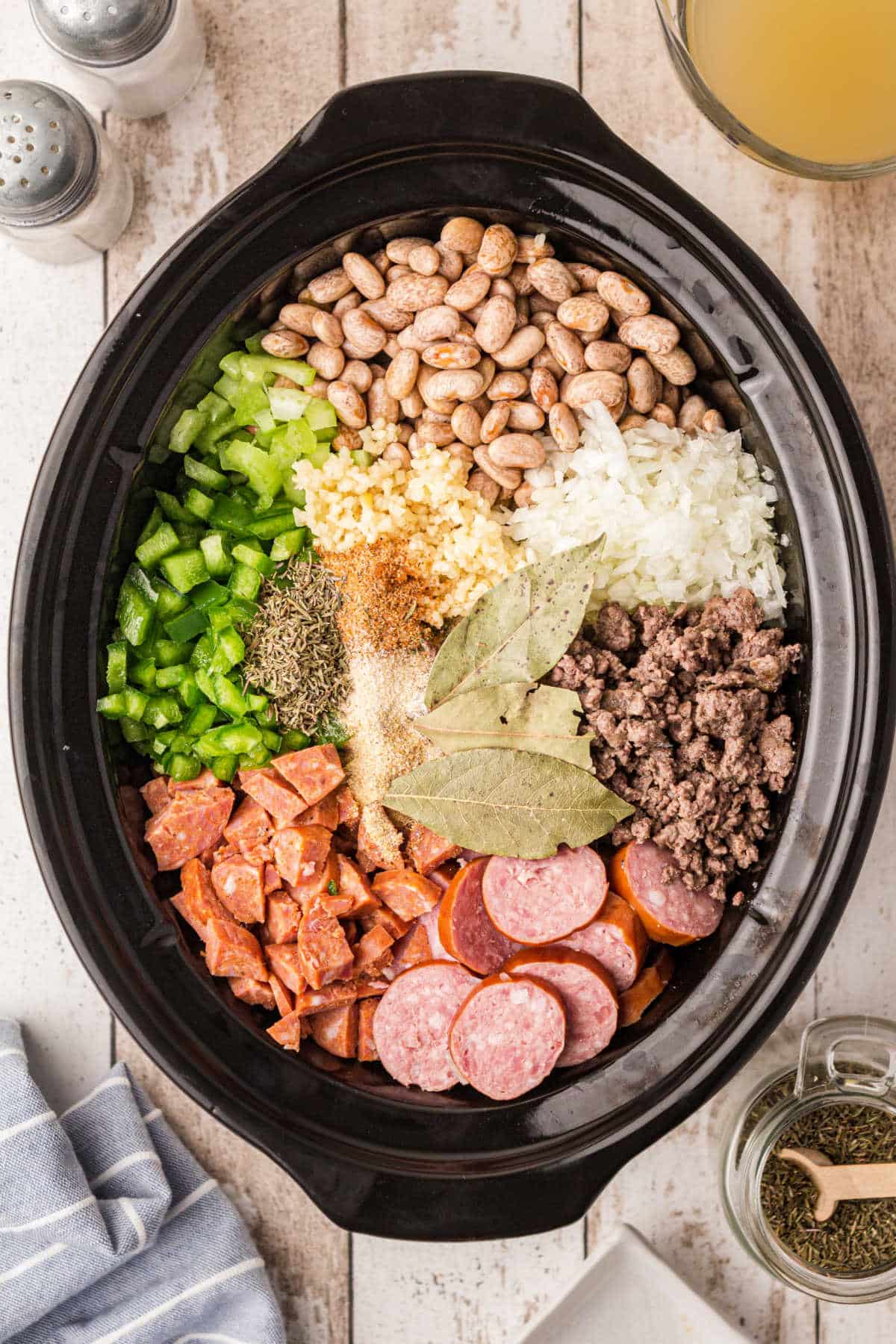slow cooker filled with the ingredients for some pinto beans