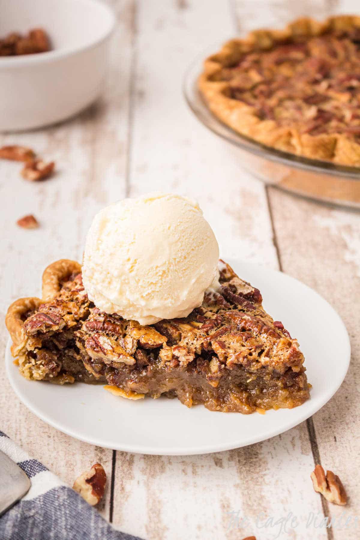 a piece of pecan pie with a scoop of ice cream on top