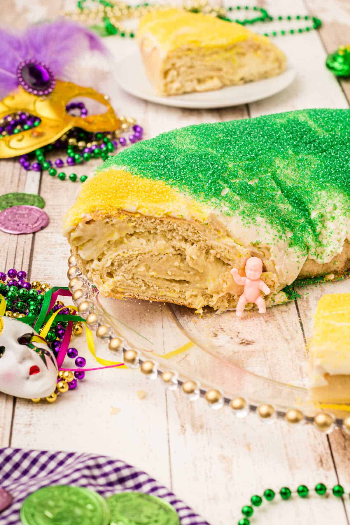 a king cake with a piece cut out with the king cake baby sitting there