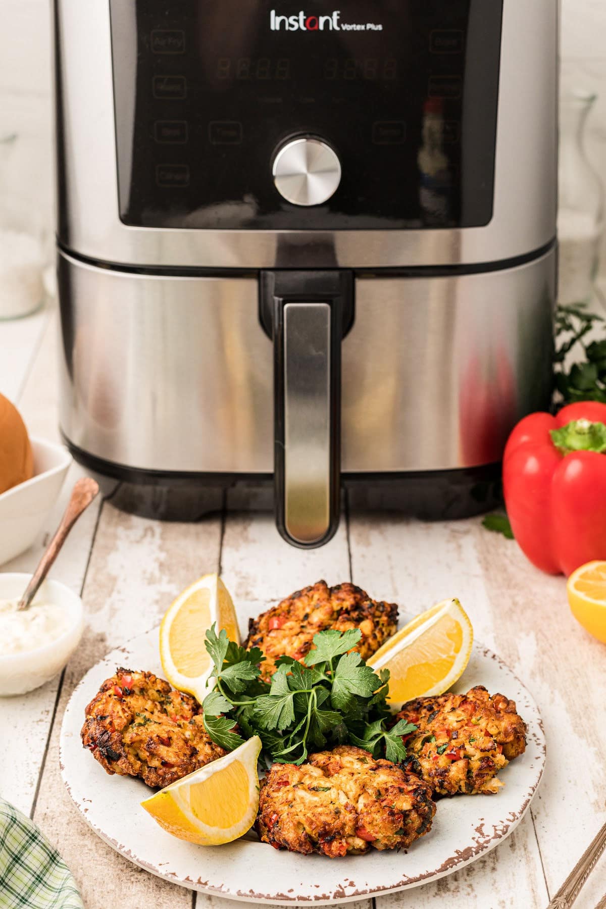 a plate of crab cakes in front of an air fryer