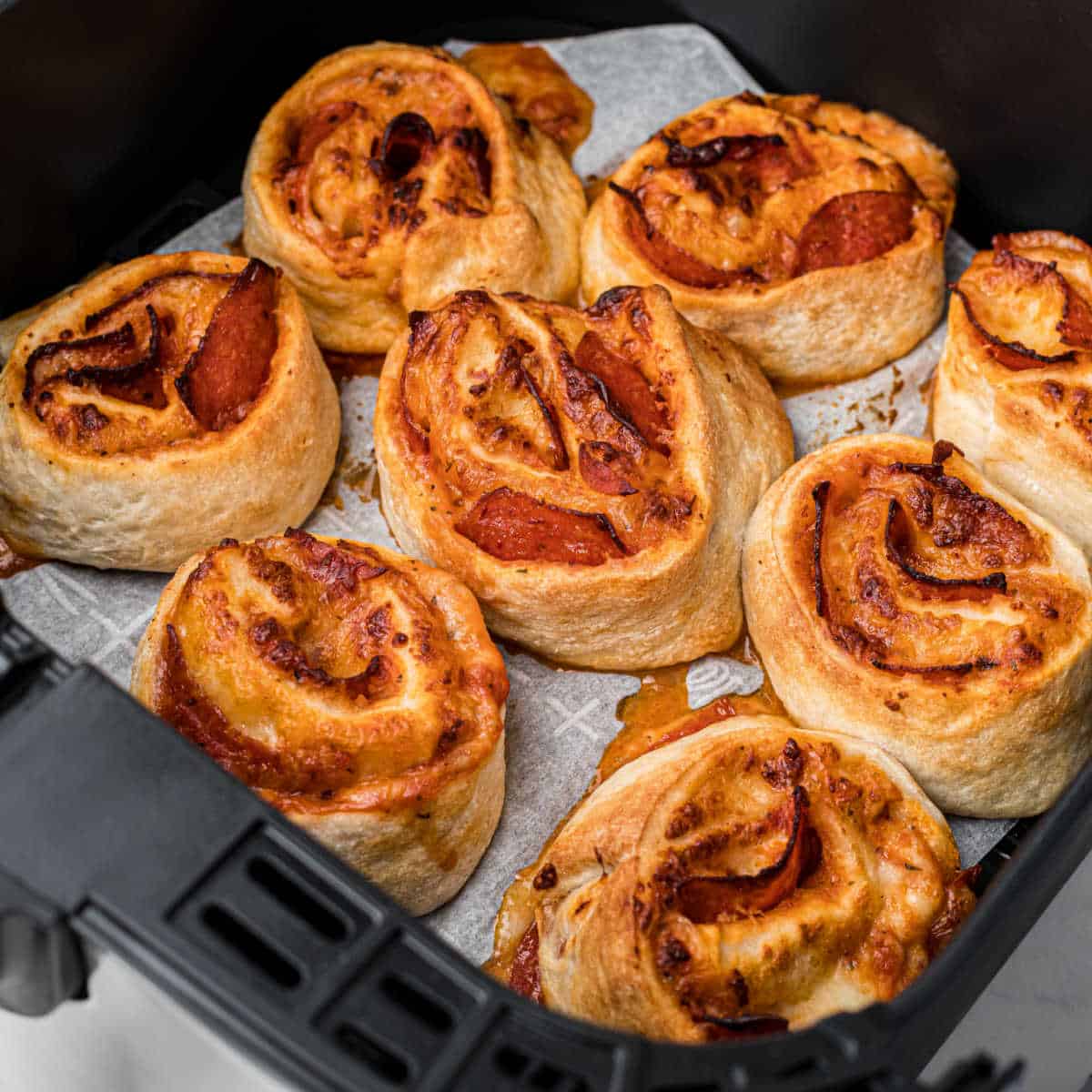 air fryer pizza rolls freshly cooked in an air fryer basket