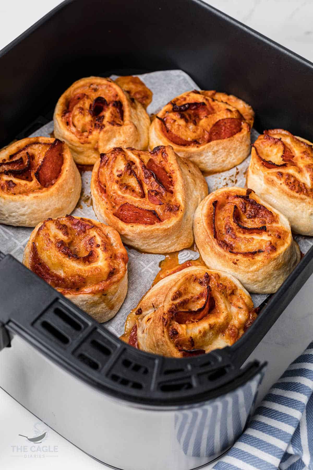 air fryer basket with pizza rolls in a single layer