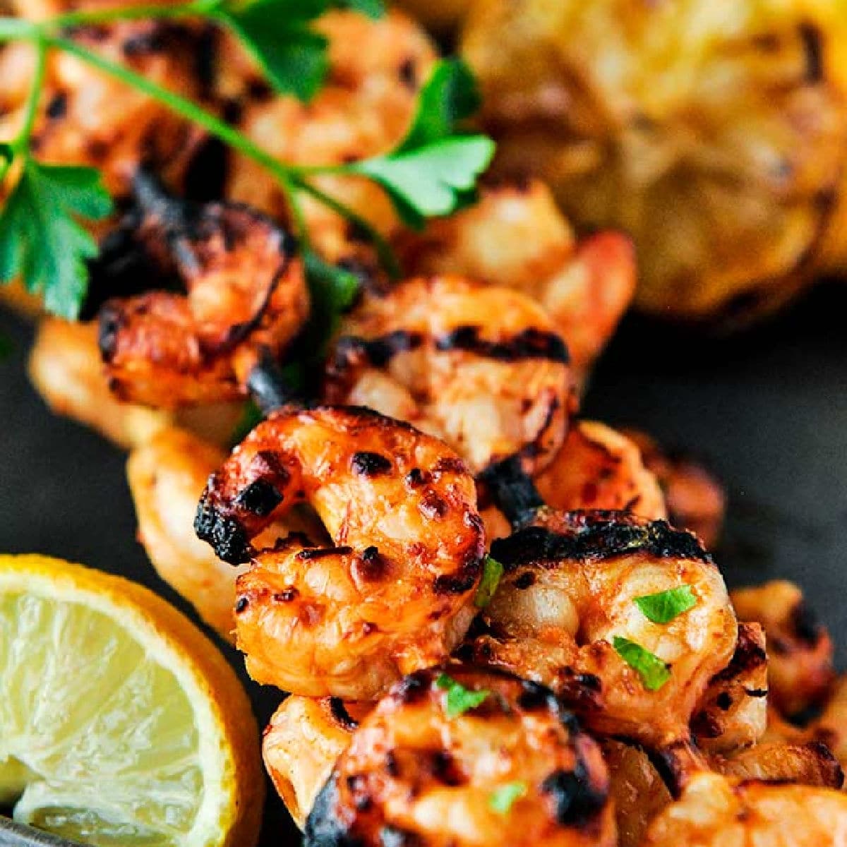 Tasty looking grilled shrimp on a skewer.