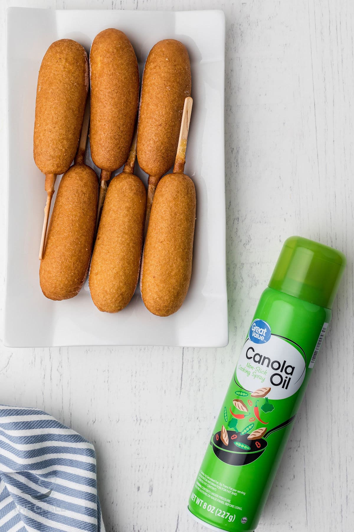 plate of corn dogs with a can of cooking spray