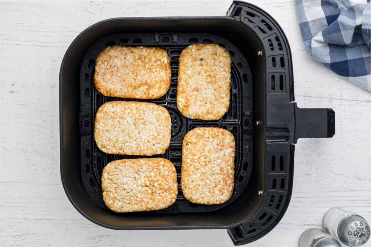 air fryer basket with hash browns lined up