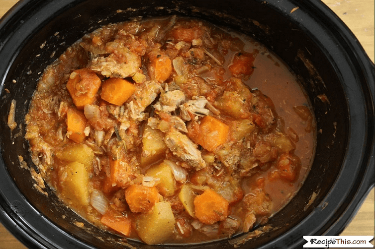 a slow cooker filled with venison stew with carrots and potatoes