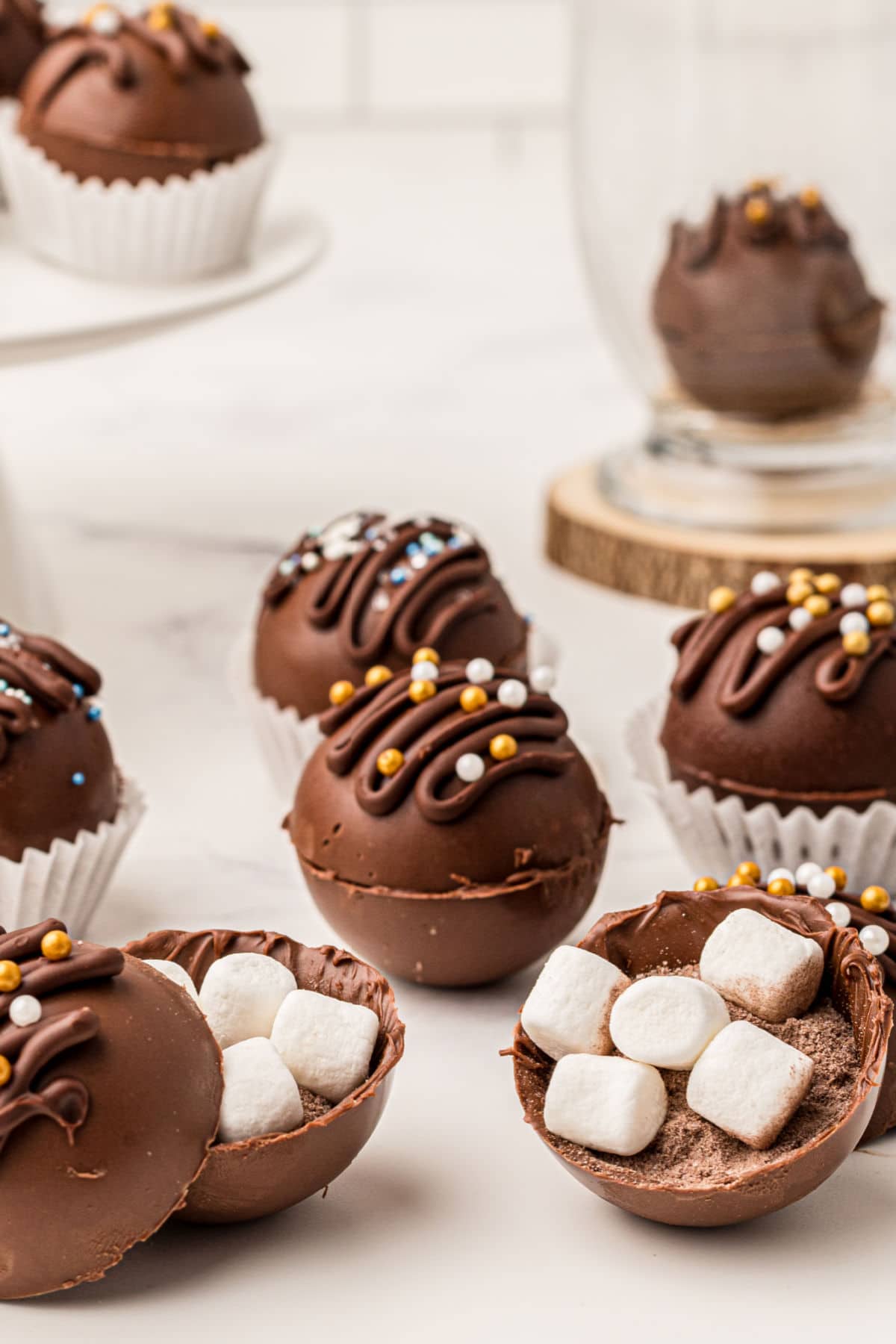 delicious hot chocolate balls filled with hot chocolate mix and marshmallows - a couple of them are opened so you can see the inside