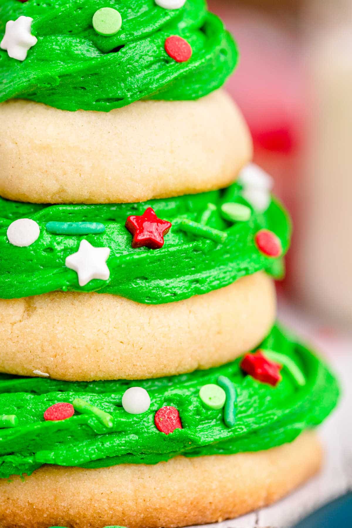 close up of image of a stack of sugar cookies with green frosting that makes it look like a christmas tree
