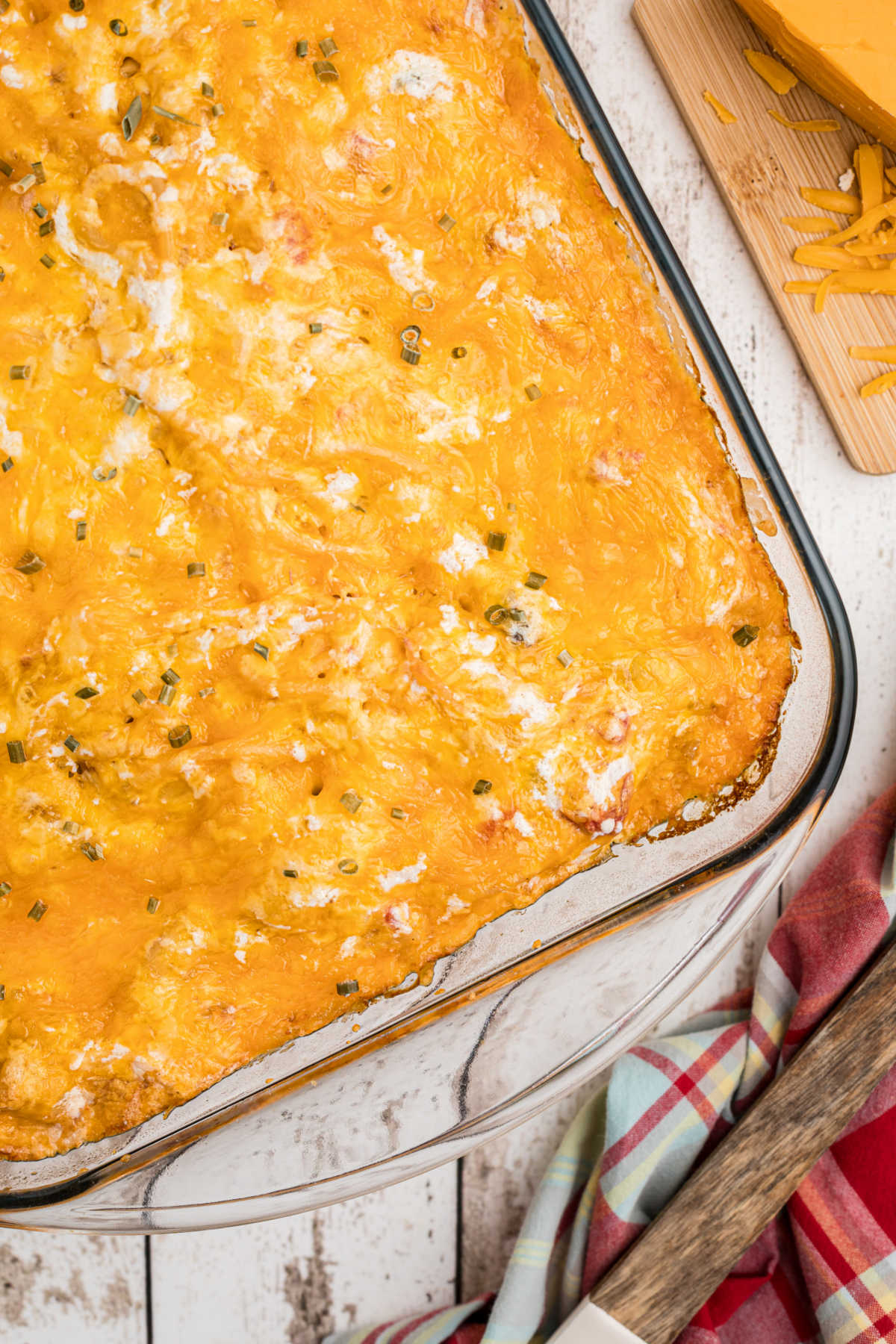 a closeup of a corner of a casserole dish filled with a cheesy chicken spaghetti