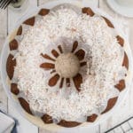 a louisiana crunch cake on a cake stand looking down from overhead, with icing and coconut