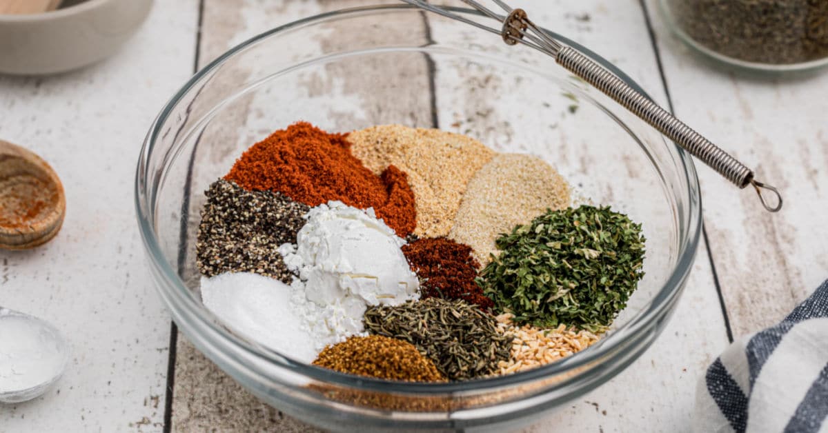 a glass bowl full of different spices