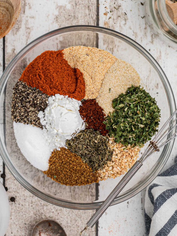 a bowl full of different spices making a creole seasoning blend