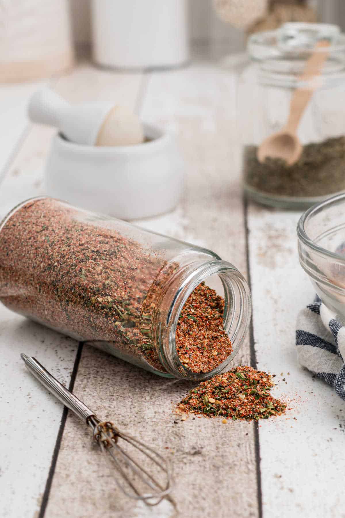 a jar full of creole seasoning that is knocked over