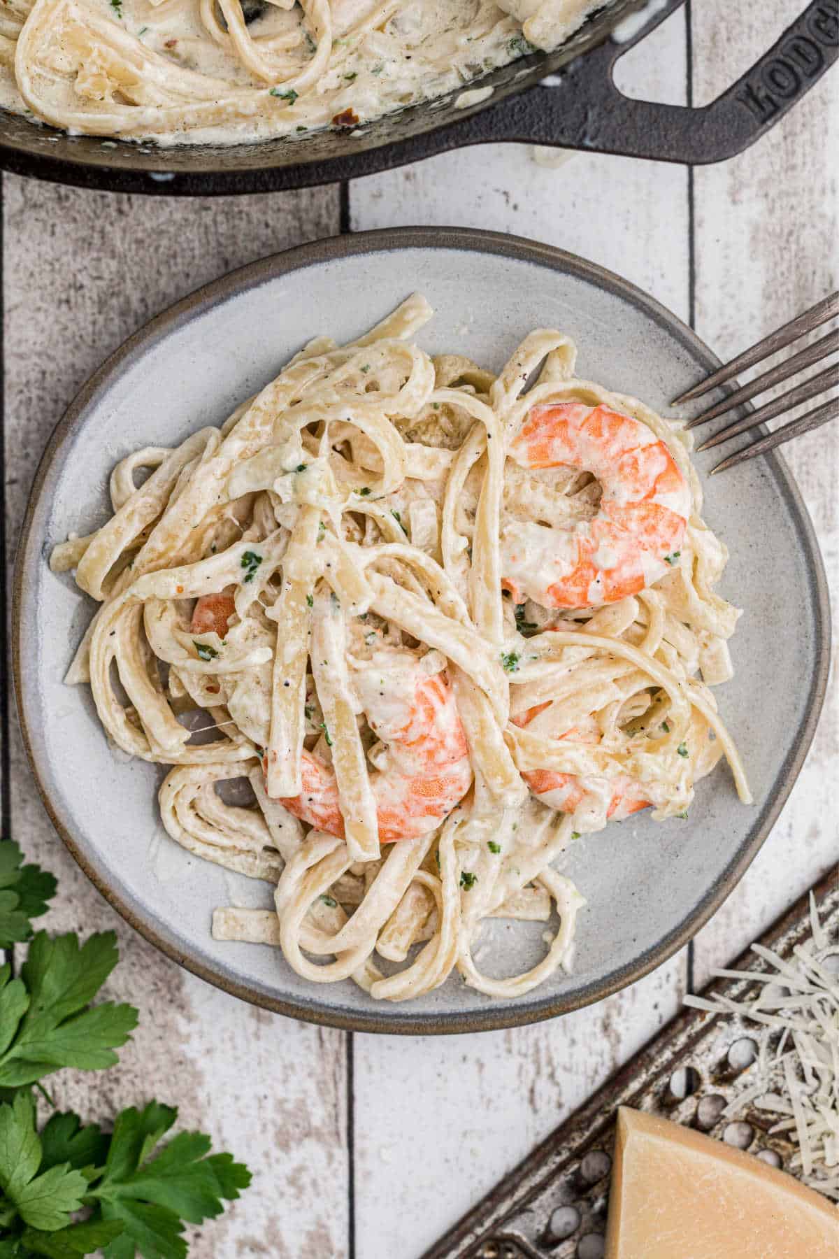 dished out shrimp alfredo bake on a plate with a fork on the side