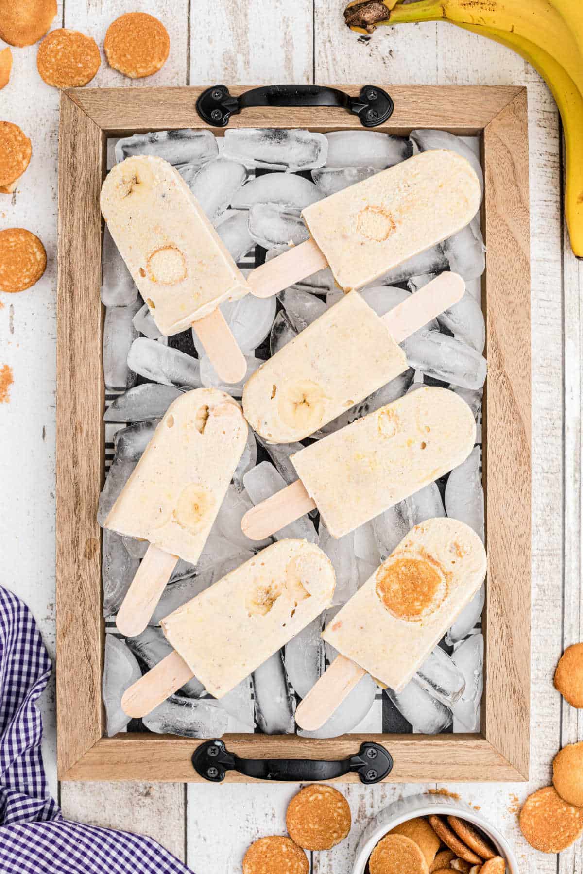 a tray with ice on it and banana pudding popsicles laying on top of the ice
