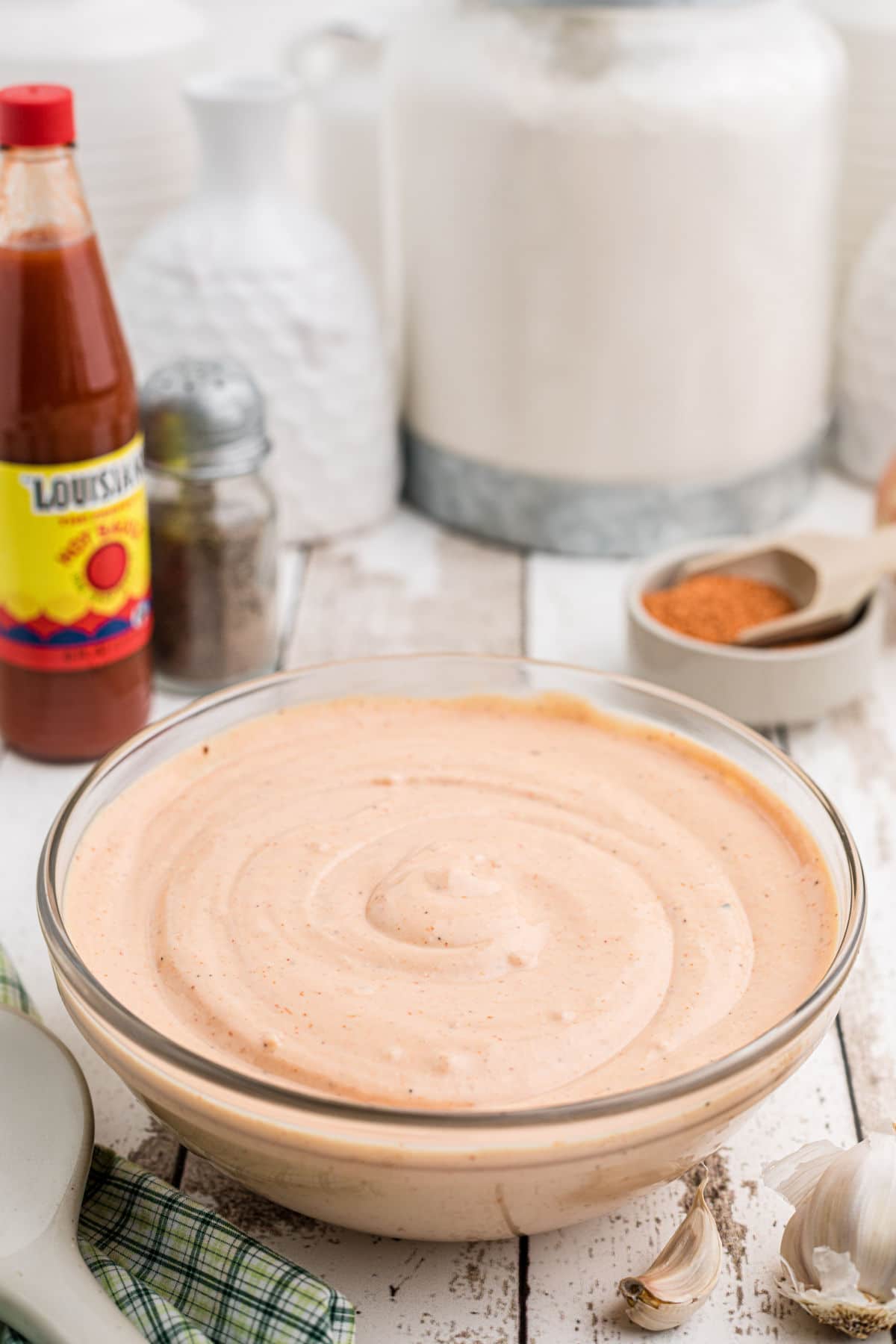 A large bowl of seafood sauce with some ingredients in the background