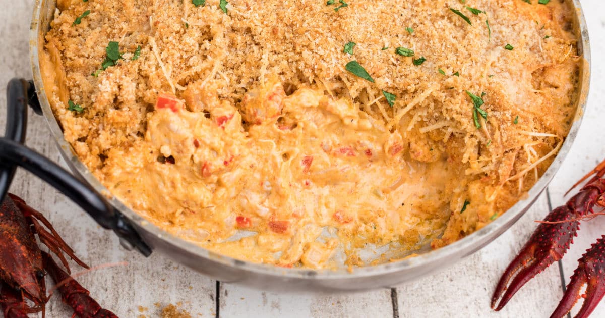 a large skillet with crawfish dip, bread crumbs on top with some of the dip gone