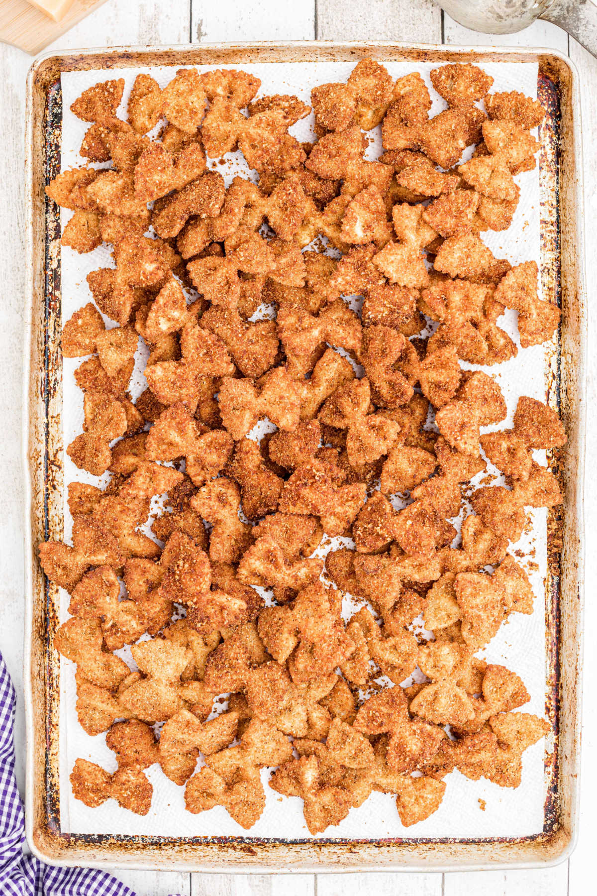 a tray full of fried bowtie pasta draining on paper towels