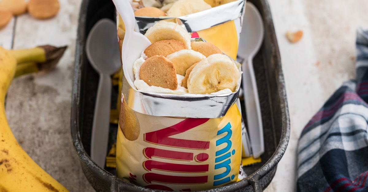 a single bag of nilla wafers filled with banana pudding with a spoon digging in