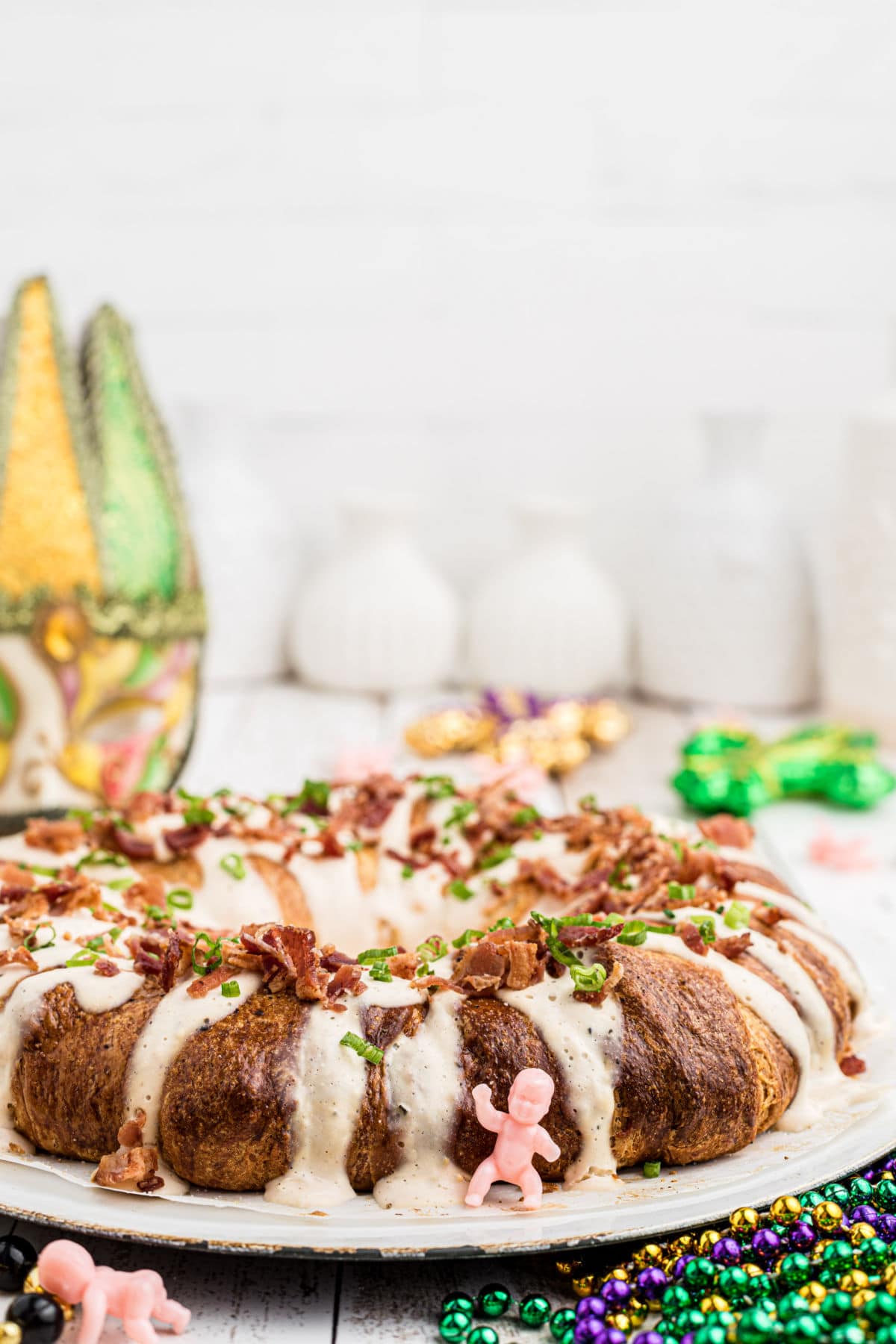 side view of a boudin king cake with a baby in front