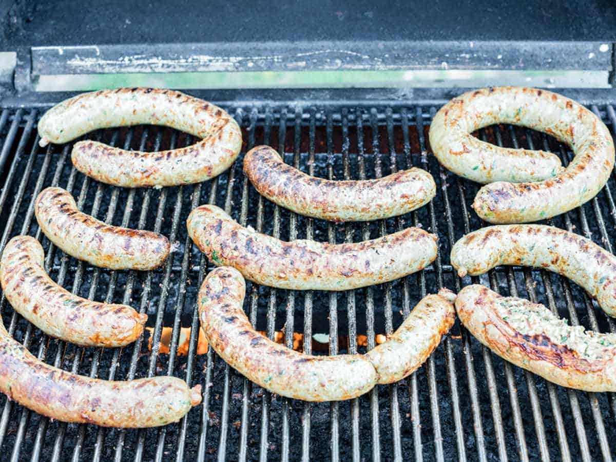 homemade boudin sausages on a barbecue pit being cooked