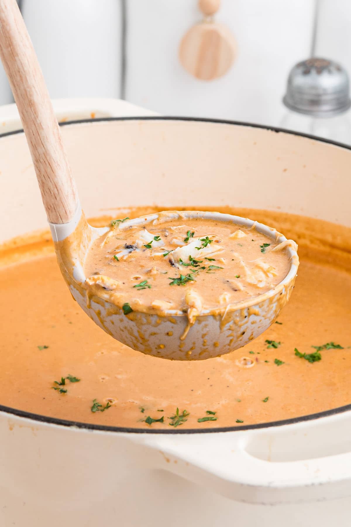 a close up of a ladle full of crab soup