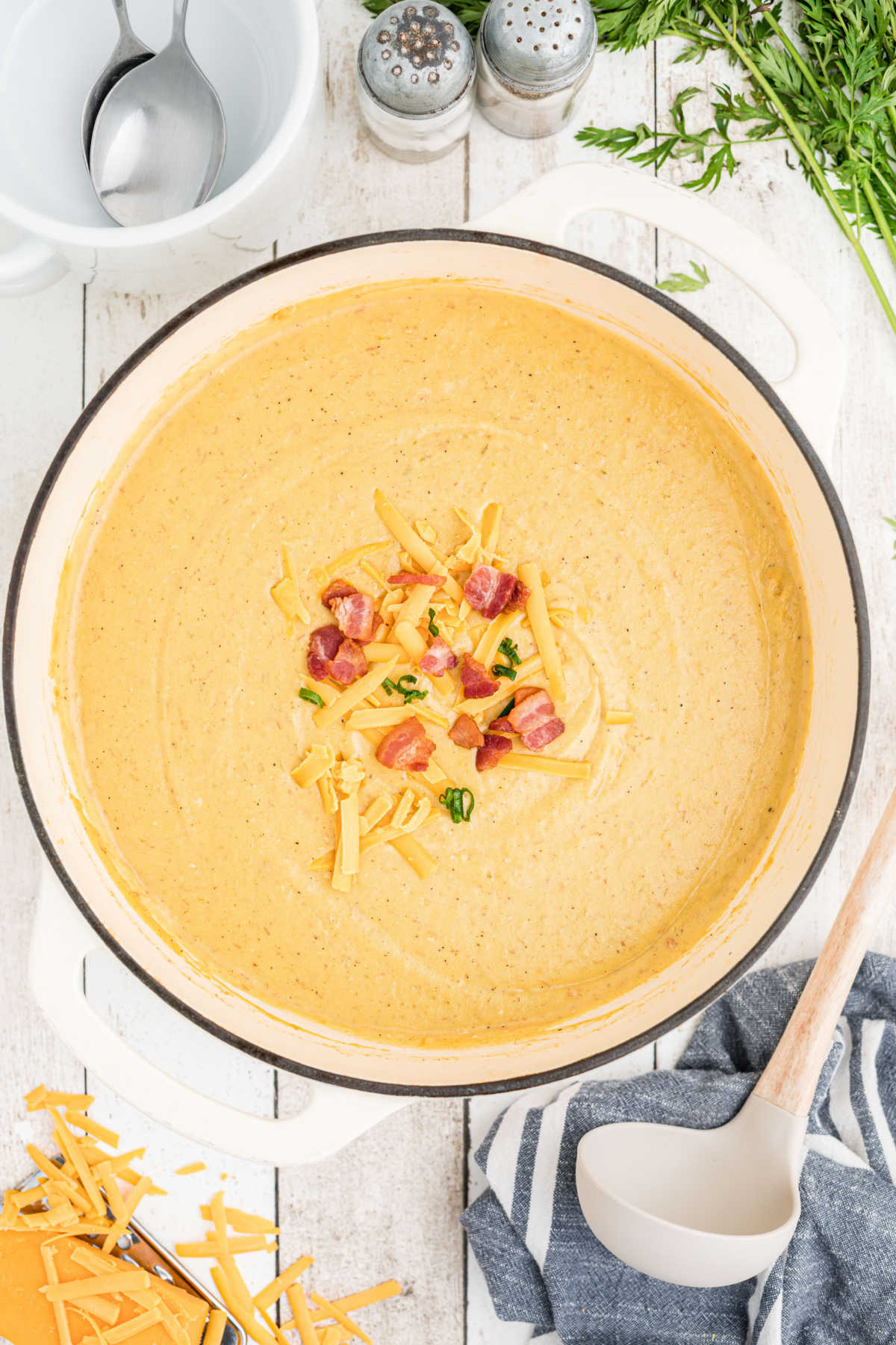 overhead image of a large Dutch oven full of saltgrass baked potato soup with some bacon and cheese sprinkled on top