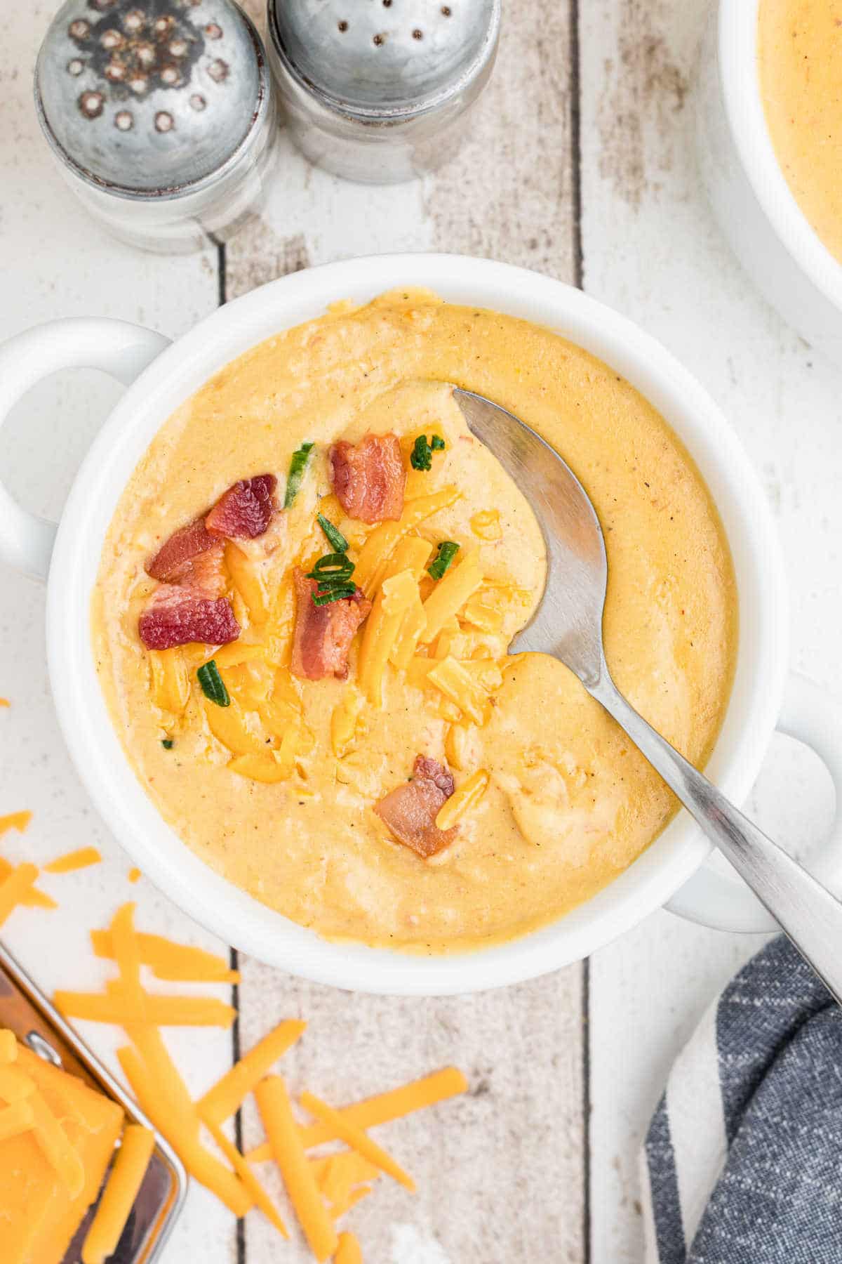 a bowl of saltgrass baked potato soup with a spoon digging in