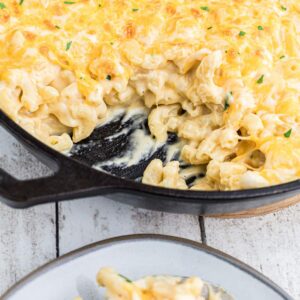 close up of a skillet of mac and cheese with some missing.