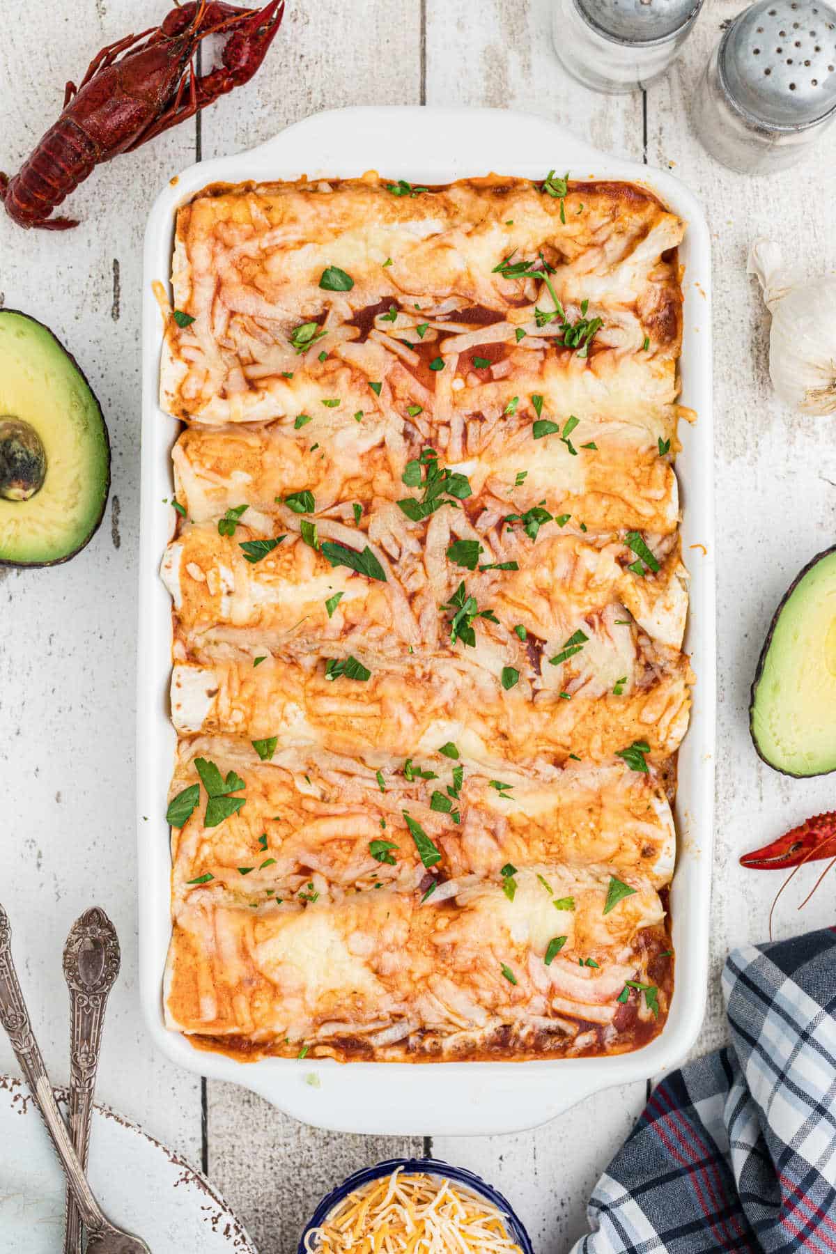 overhead shot of a casserole dish with crawfish enchiladas topped with cheese