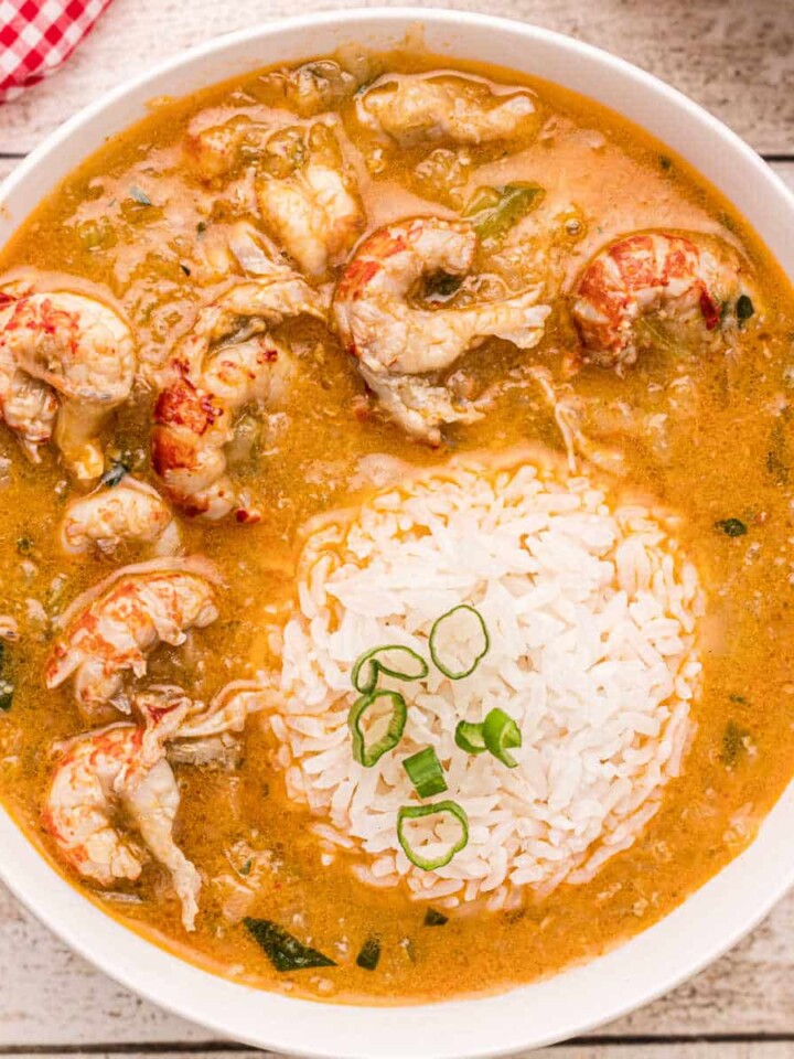 Bowl of crawfish etouffee with rice scoop in the middle.