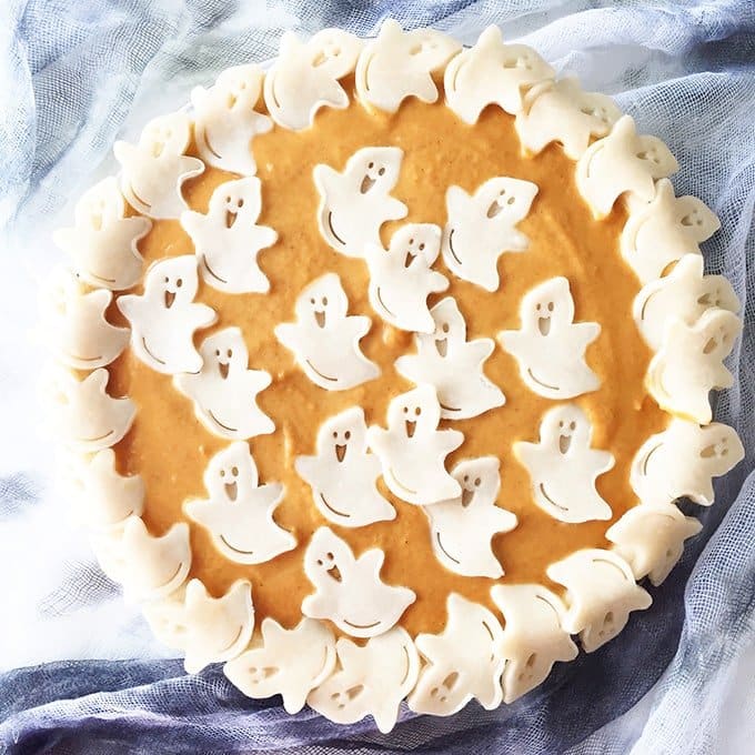 pumpkin pie with ghost shapes cut out of pastry on top