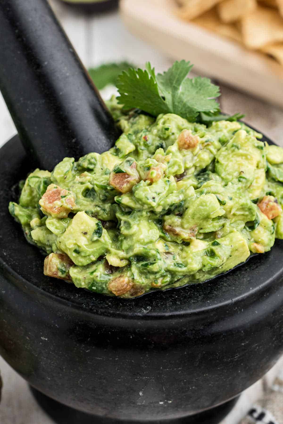 Molcajete Guacamole - a mortar and pestle filled with guacamole.