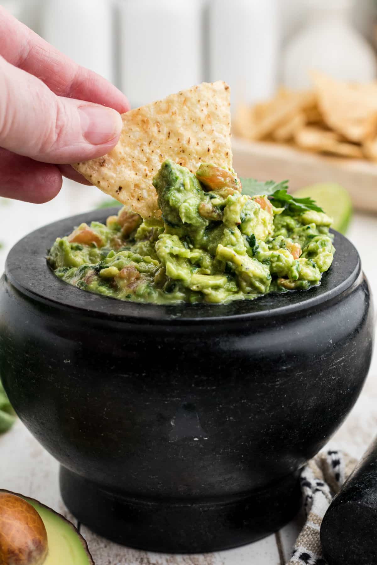 A chip being dipped into some molcajete guacamole.