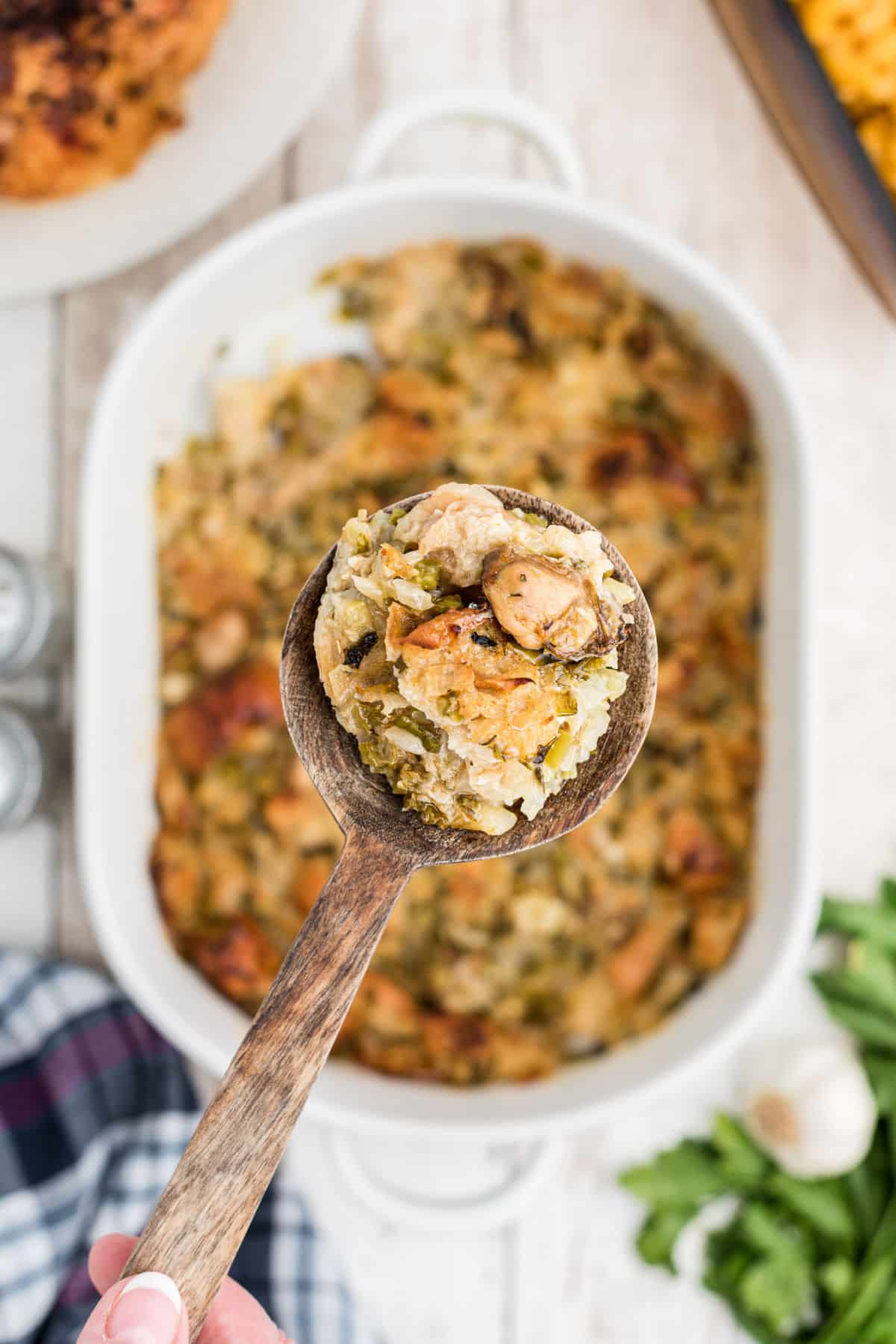 a baked oyster dressing with a spoon showing a scoop.