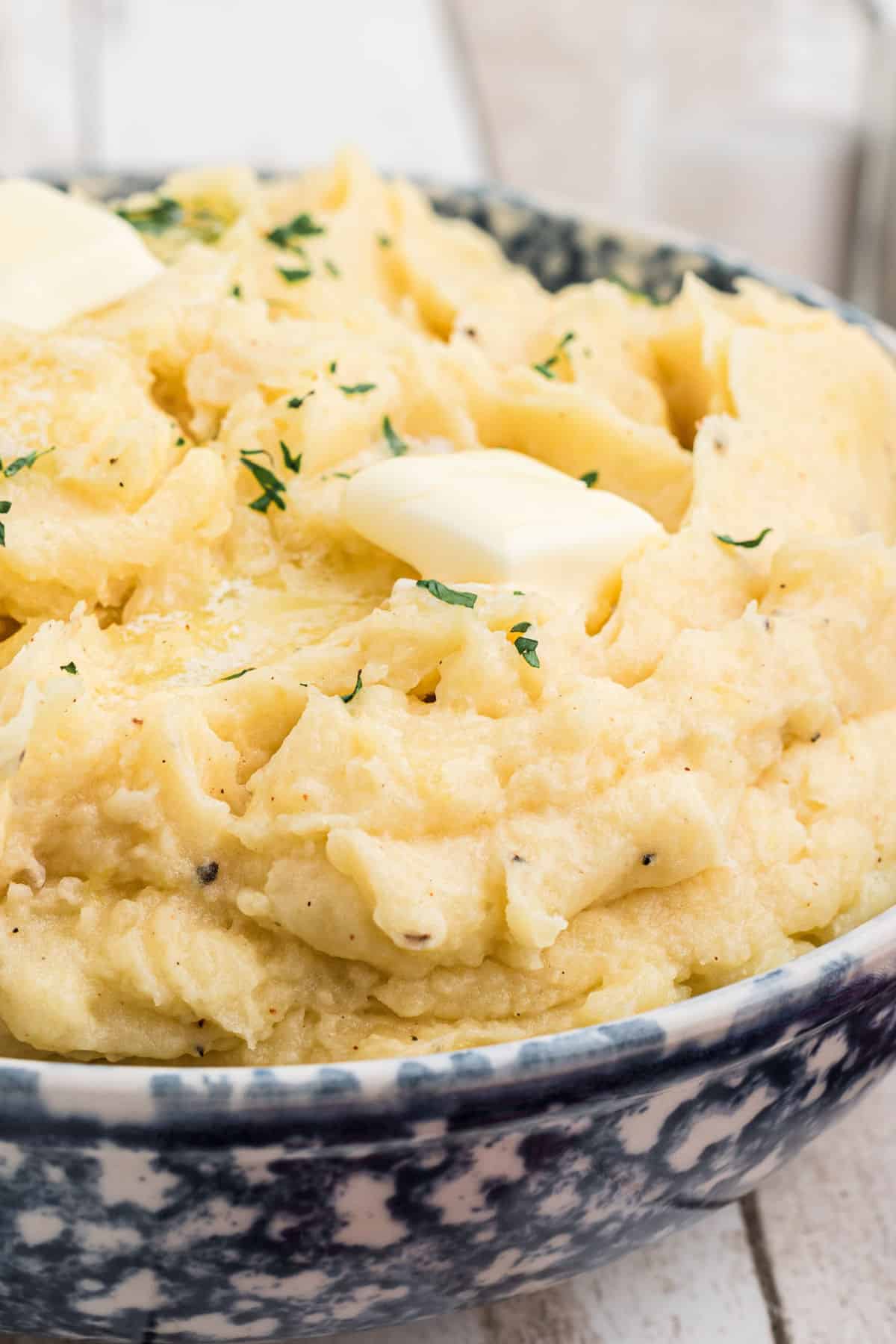 A close up of a large bowl of copycat Popeyes mashed potatoes with some butter melting on top.
