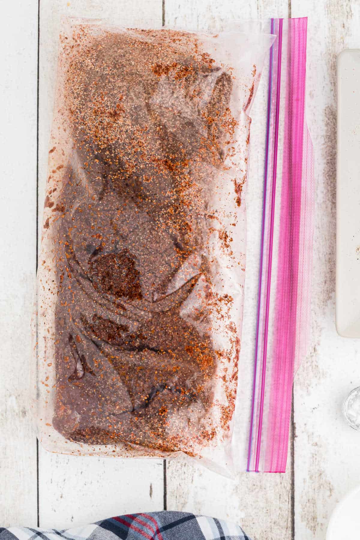 venison backstrap in a resealable bag with a rub