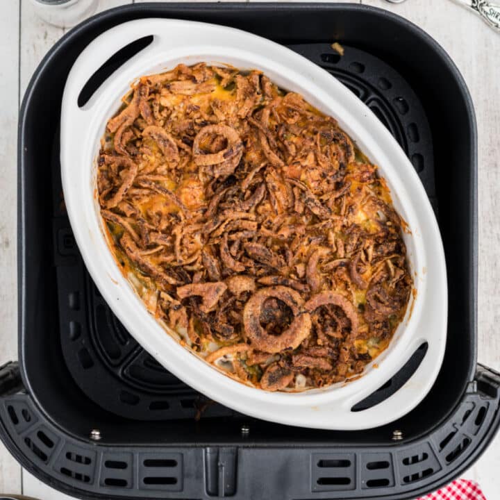 Overhead view of a dish inside the basket of an air fryer with green bean casserole.