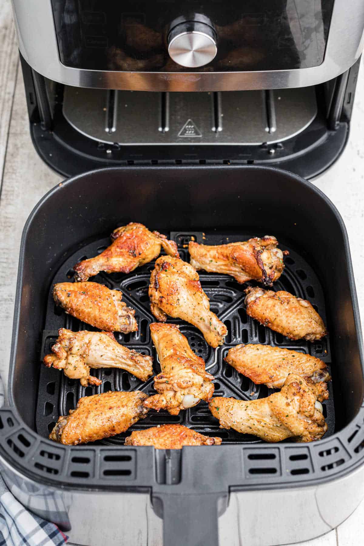 A shot of some air fryer ranch chicken wings in an air fryer basket.
