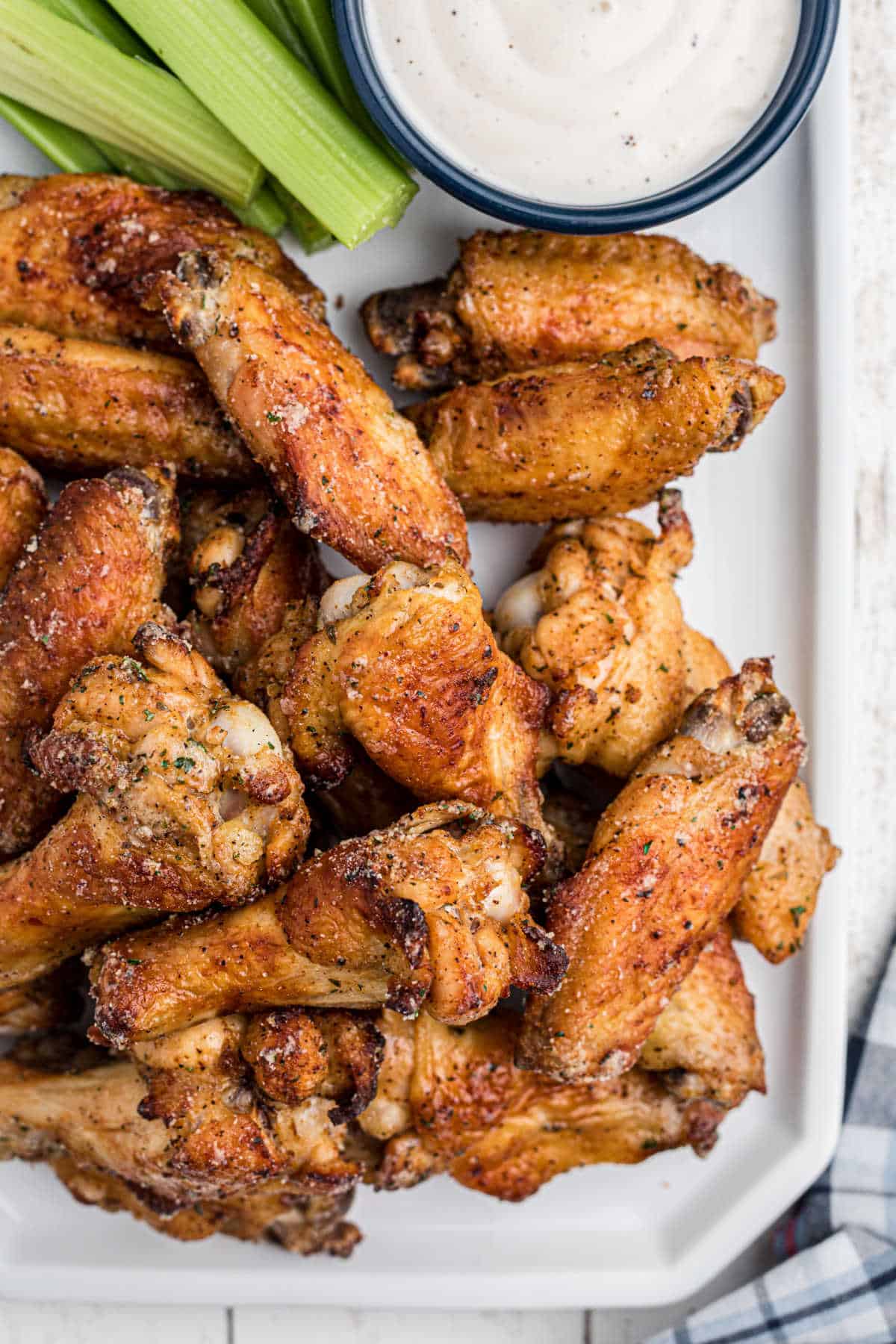 Overhead shot of some air fryer ranch chicken wings, close up, with some celery and dip.