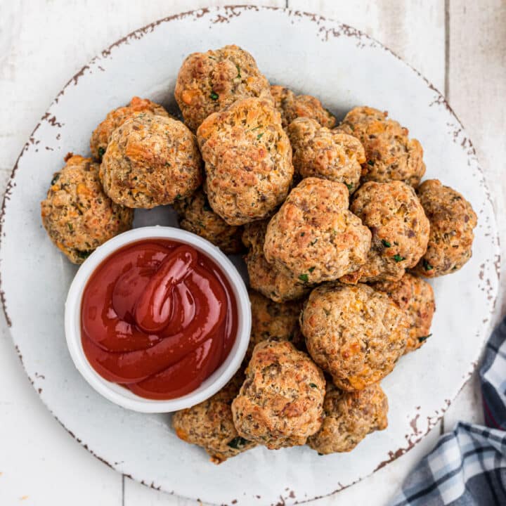 Close up overhead shot of air fryer sausage balls on a plate with ketchup.