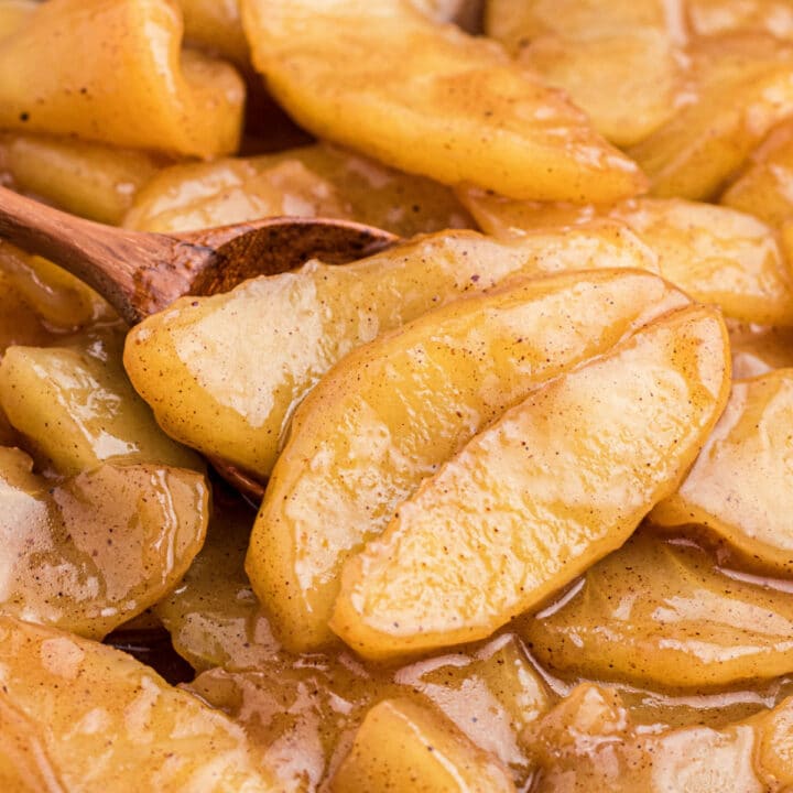 Close up of fried apples with a wooden spoon.