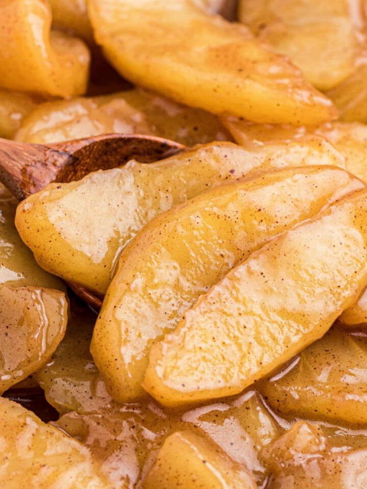 Close up of fried apples with a wooden spoon.