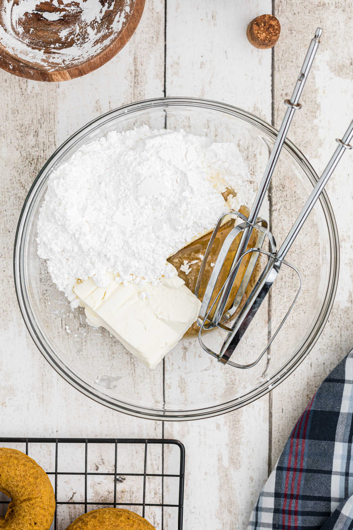 A bowl of ingredients needed to make cream cheese frosting with some beaters.
