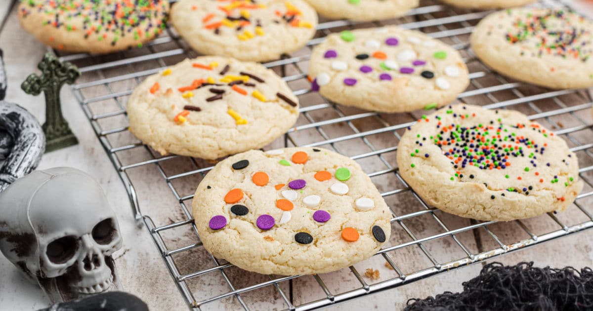 a wire rack with halloween cookies with sprinkles cooling.