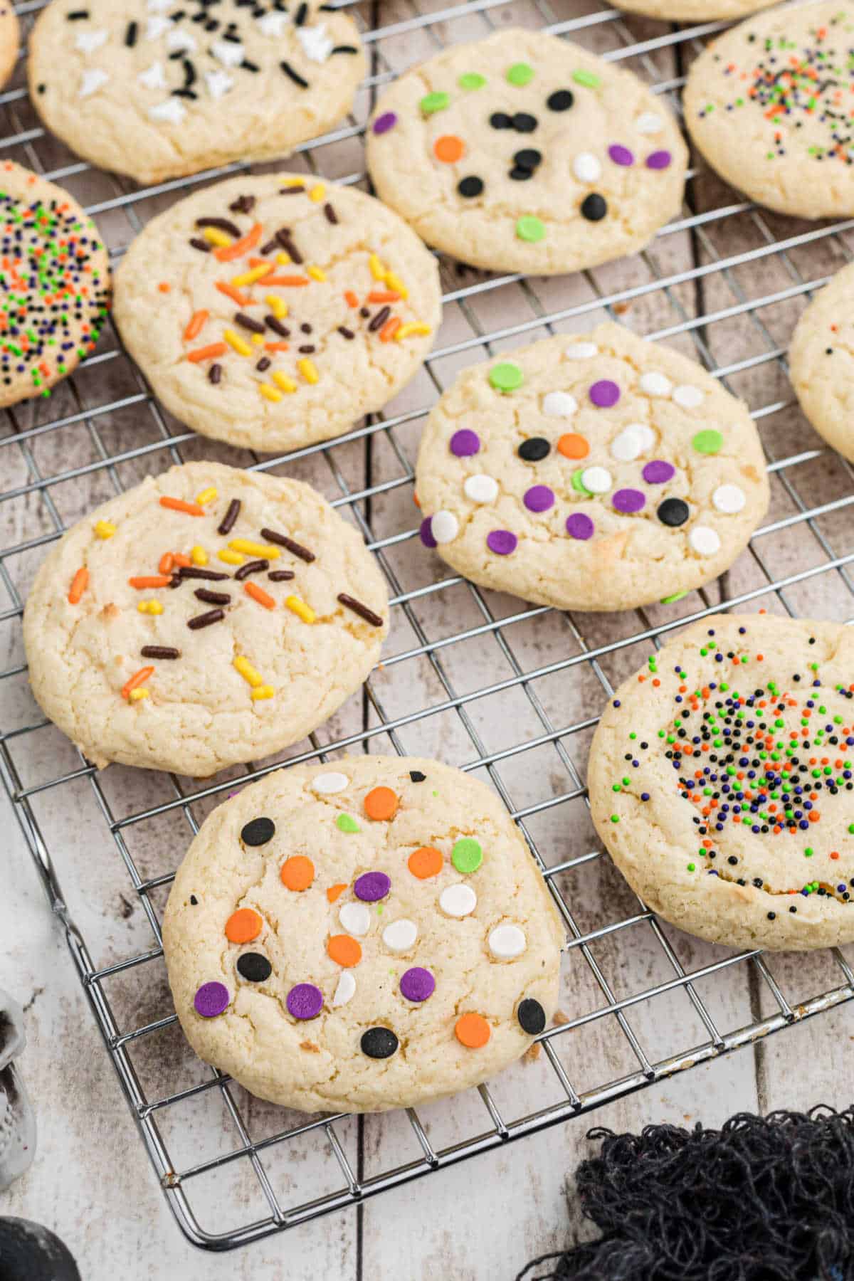 Overhead shot of a wire rack with some cookies cooling with halloween sprinkles on top.